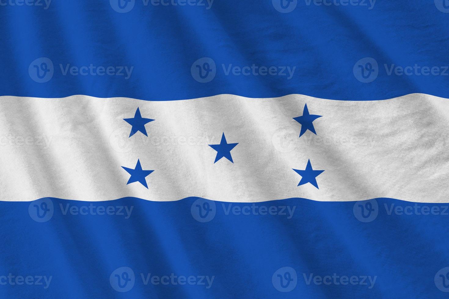 Honduras flag with big folds waving close up under the studio light indoors. The official symbols and colors in banner photo