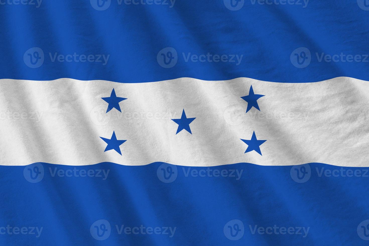 bandera de honduras con grandes pliegues ondeando de cerca bajo la luz del estudio en el interior. los símbolos y colores oficiales en banner foto