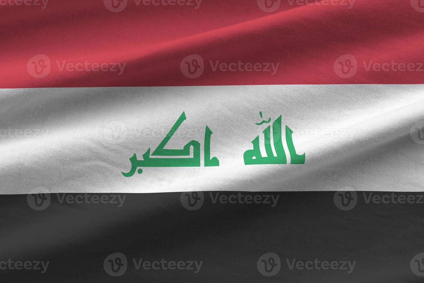 Iraq flag with big folds waving close up under the studio light indoors. The official symbols and colors in banner photo