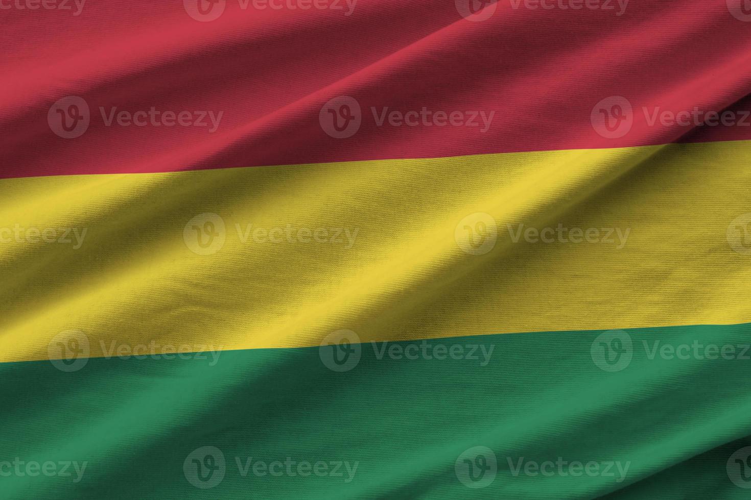Bolivia flag with big folds waving close up under the studio light indoors. The official symbols and colors in banner photo