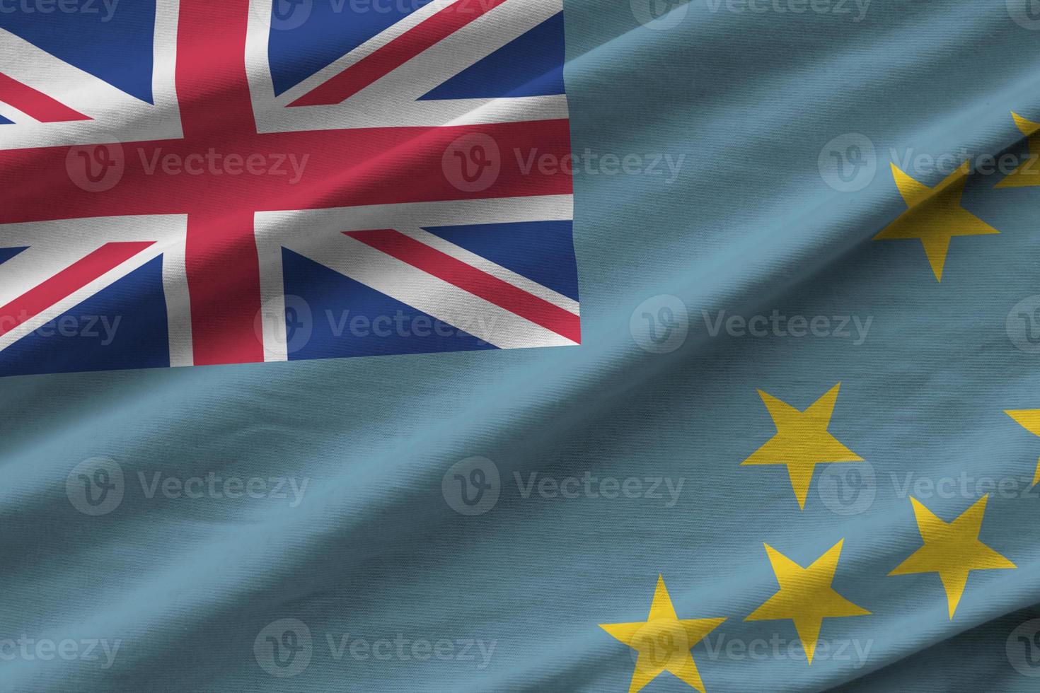 Tuvalu flag with big folds waving close up under the studio light indoors. The official symbols and colors in banner photo