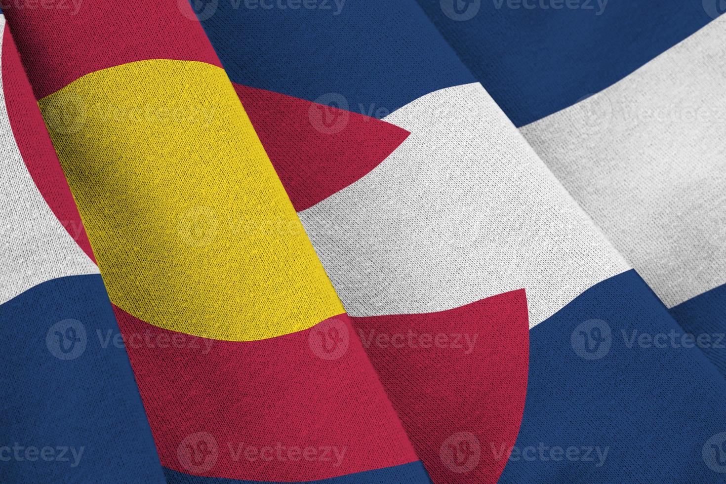 colorado bandera del estado de estados unidos con grandes pliegues ondeando de cerca bajo la luz del estudio en el interior. los símbolos y colores oficiales en banner foto