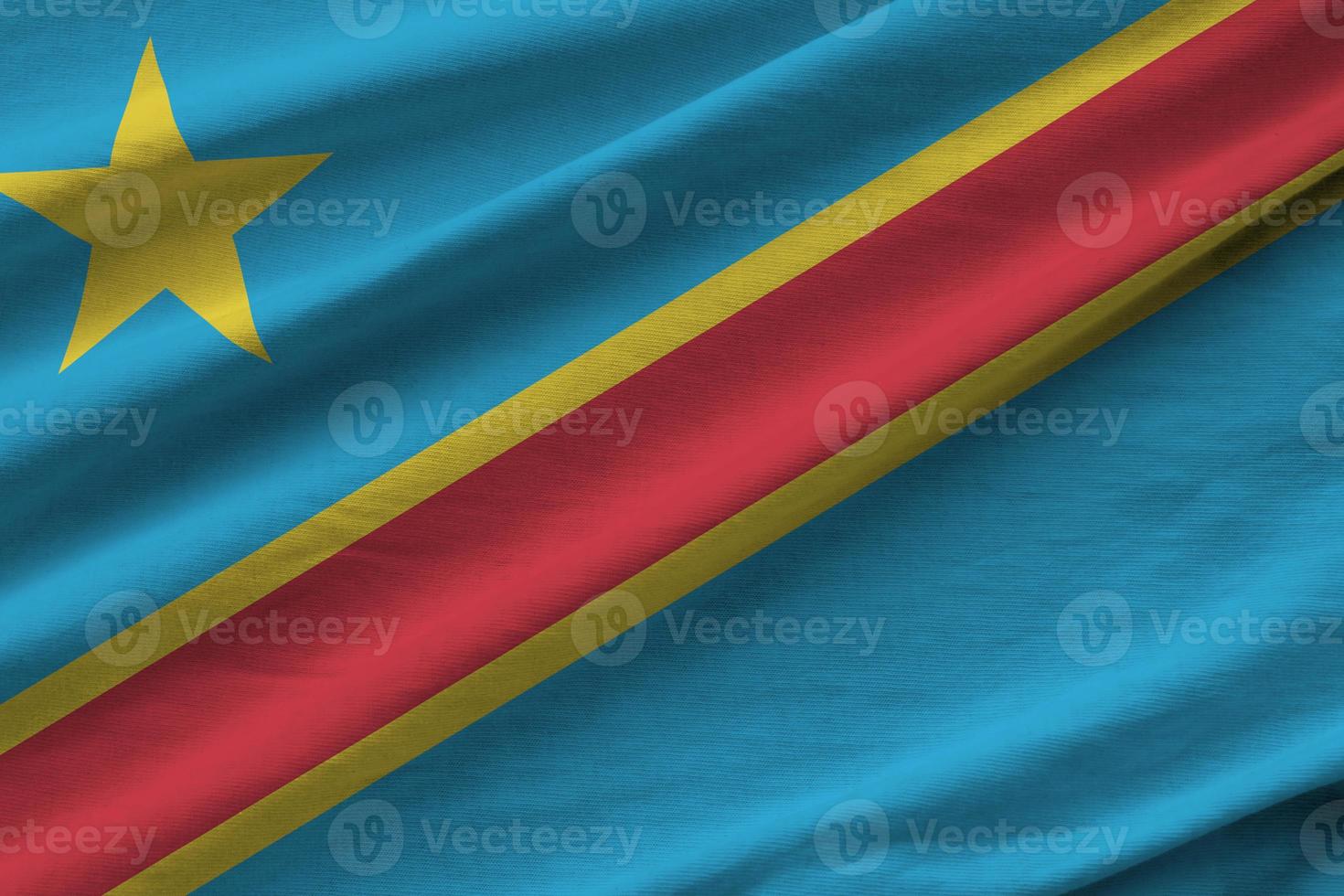 Democratic Republic of the Congo flag with big folds waving close up under the studio light indoors. The official symbols and colors in banner photo