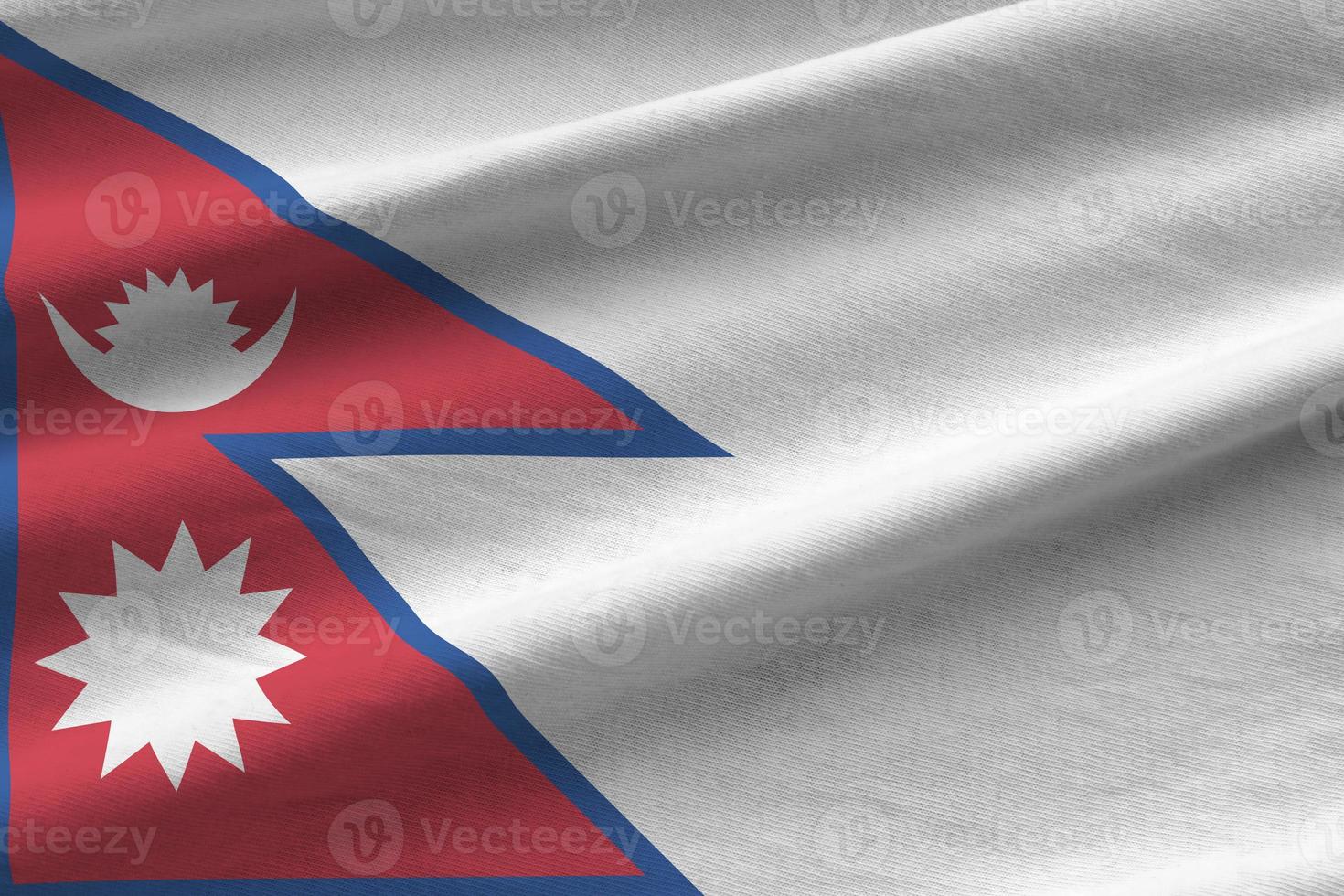 Nepal flag with big folds waving close up under the studio light indoors. The official symbols and colors in banner photo