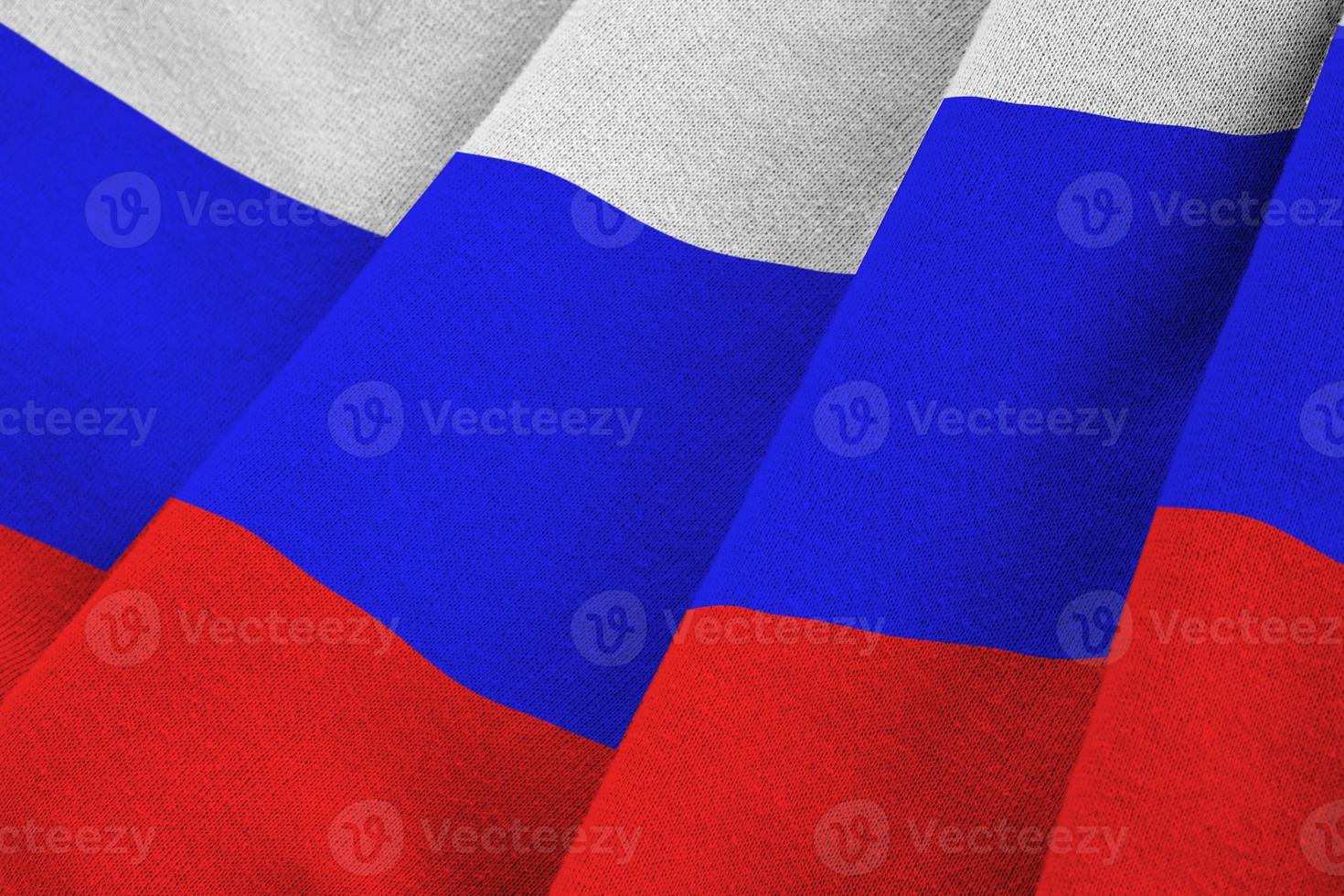 Russia flag with big folds waving close up under the studio light indoors. The official symbols and colors in banner photo