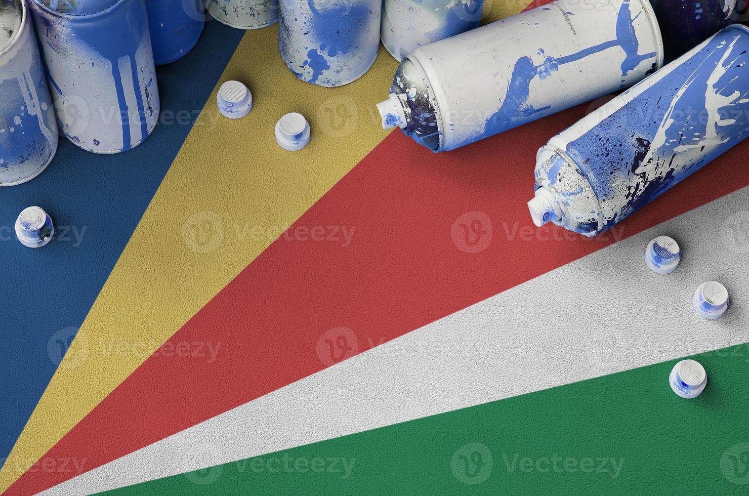 Seychelles flag and few used aerosol spray cans for graffiti painting. Street art culture concept photo