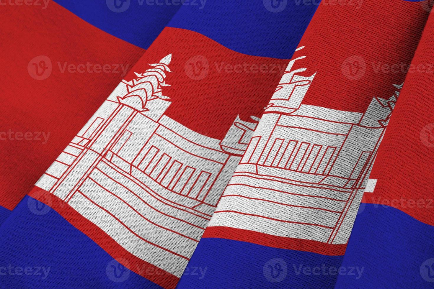 Cambodia flag with big folds waving close up under the studio light indoors. The official symbols and colors in banner photo
