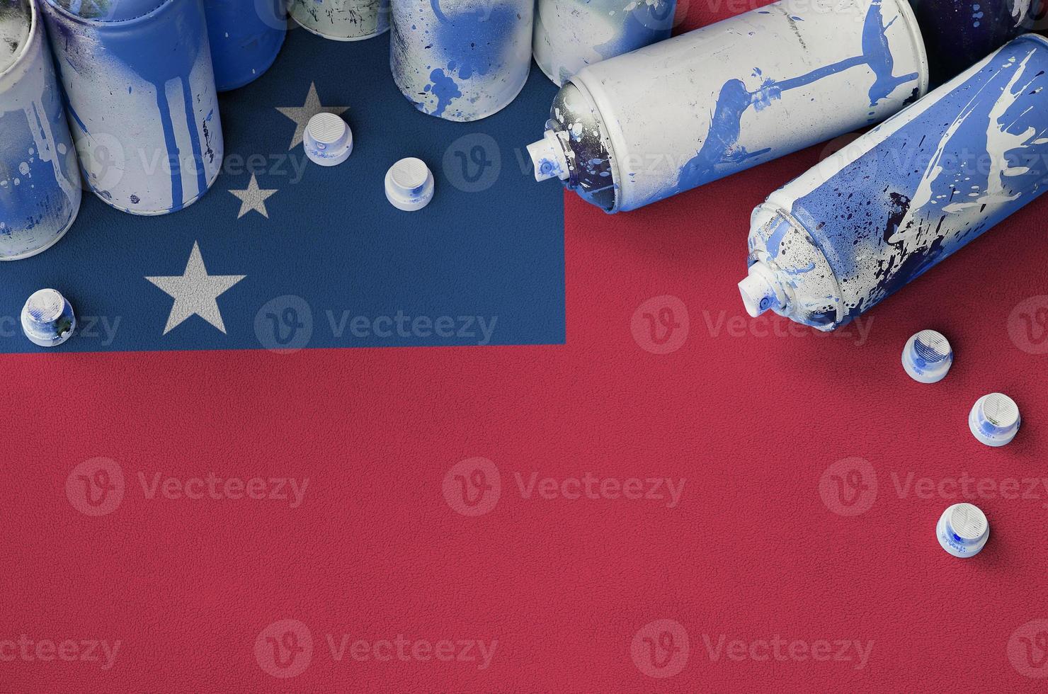 Samoa flag and few used aerosol spray cans for graffiti painting. Street art culture concept photo