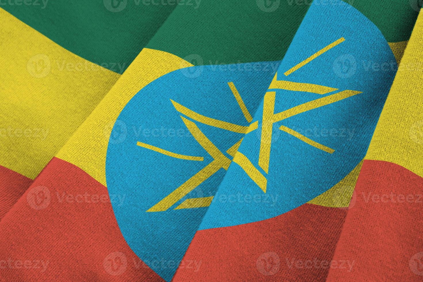 Ethiopia flag with big folds waving close up under the studio light indoors. The official symbols and colors in banner photo