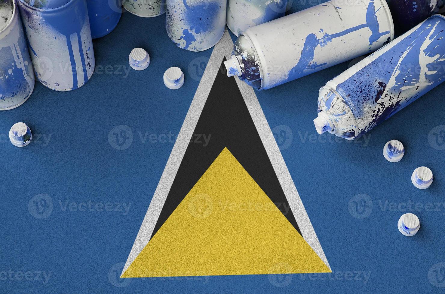 Saint Lucia flag and few used aerosol spray cans for graffiti painting. Street art culture concept photo