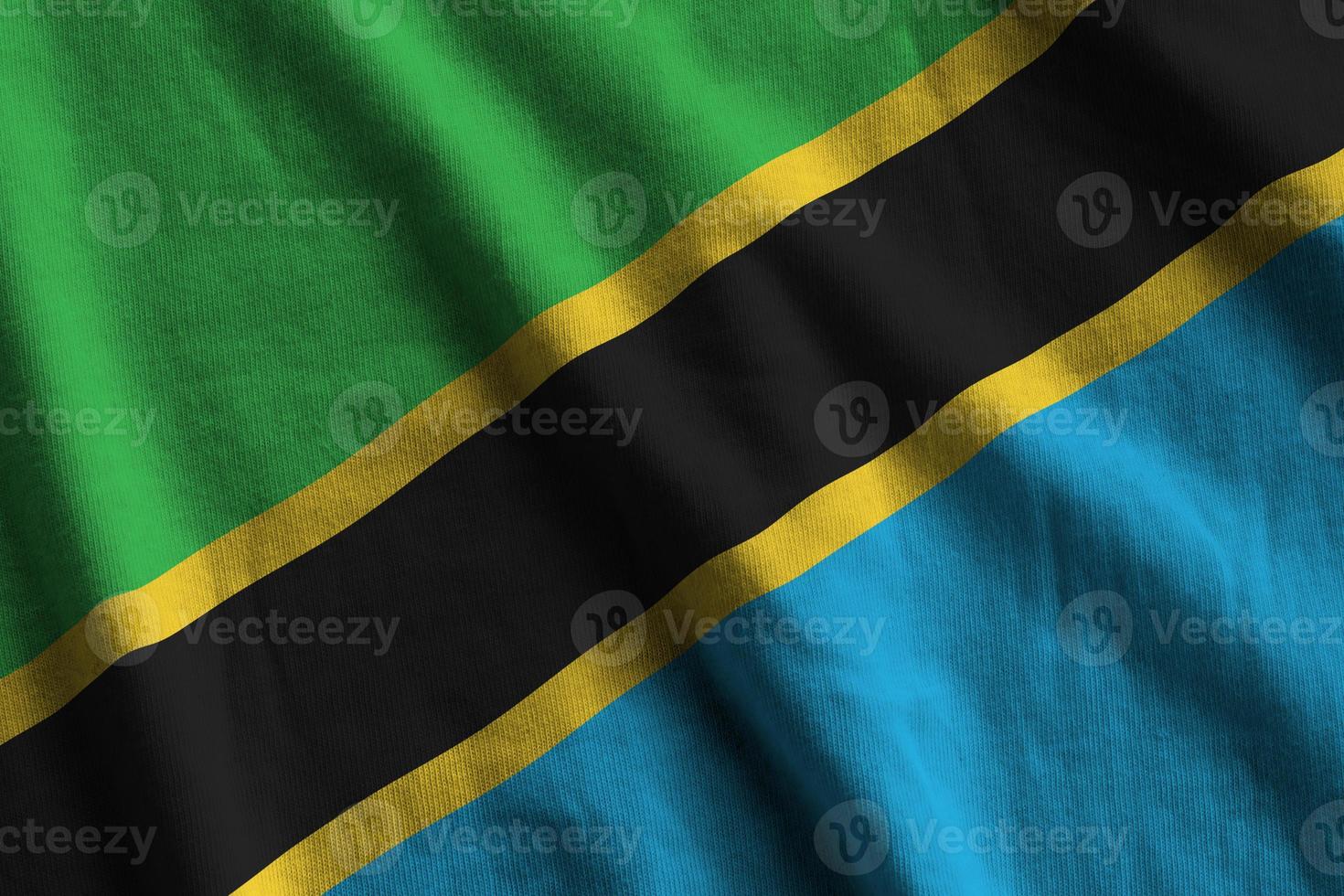 Tanzania flag with big folds waving close up under the studio light indoors. The official symbols and colors in banner photo