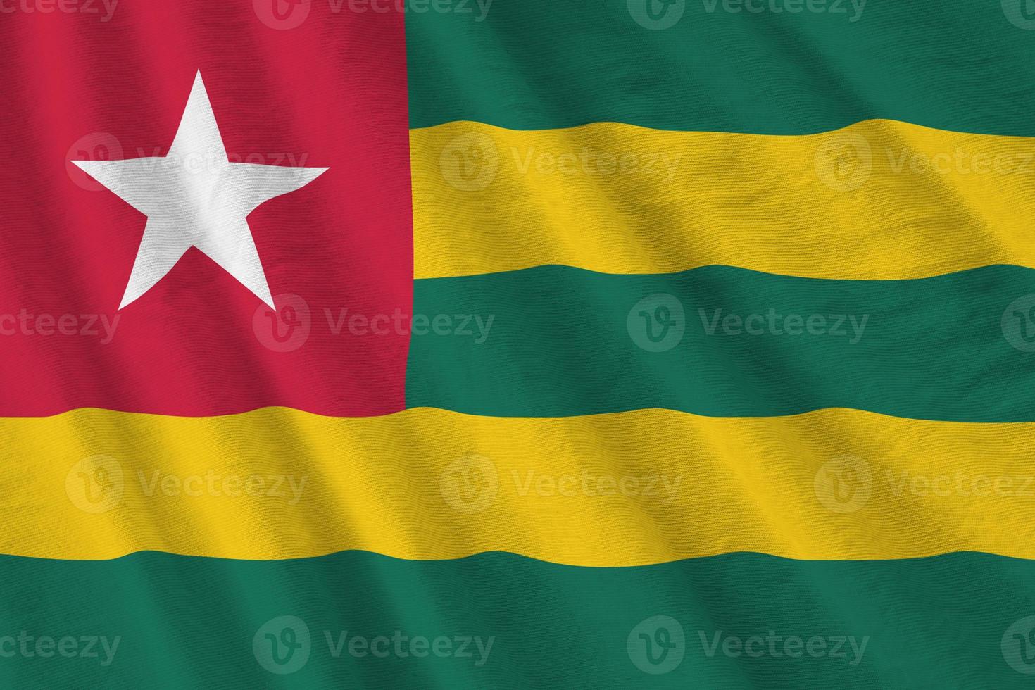 Togo flag with big folds waving close up under the studio light indoors. The official symbols and colors in banner photo