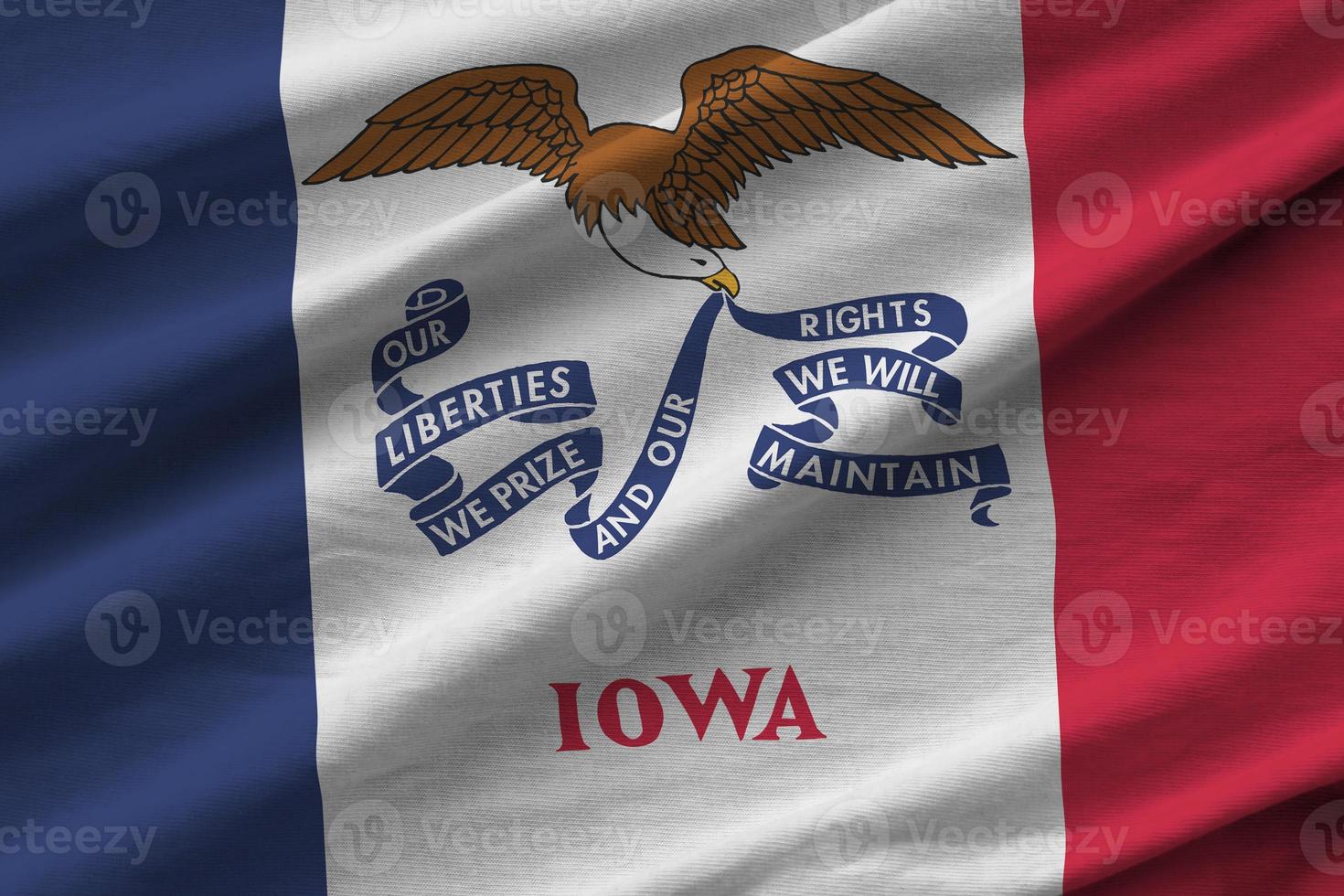 Iowa US state flag with big folds waving close up under the studio light indoors. The official symbols and colors in banner photo