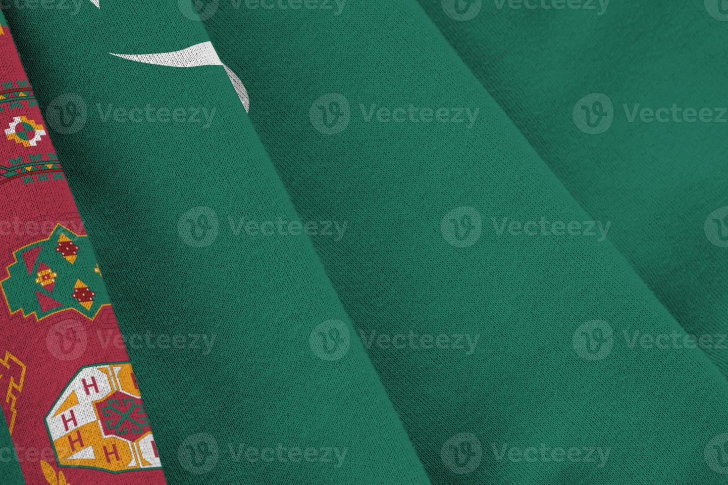 Turkmenistan flag with big folds waving close up under the studio light indoors. The official symbols and colors in banner photo