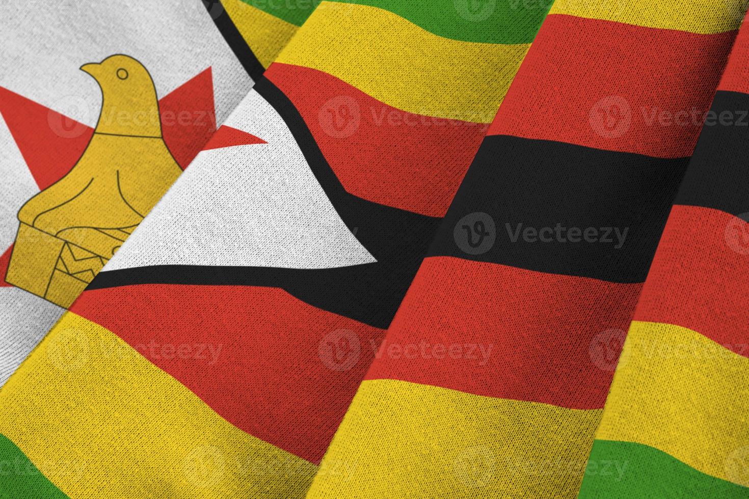 Zimbabwe flag with big folds waving close up under the studio light indoors. The official symbols and colors in banner photo