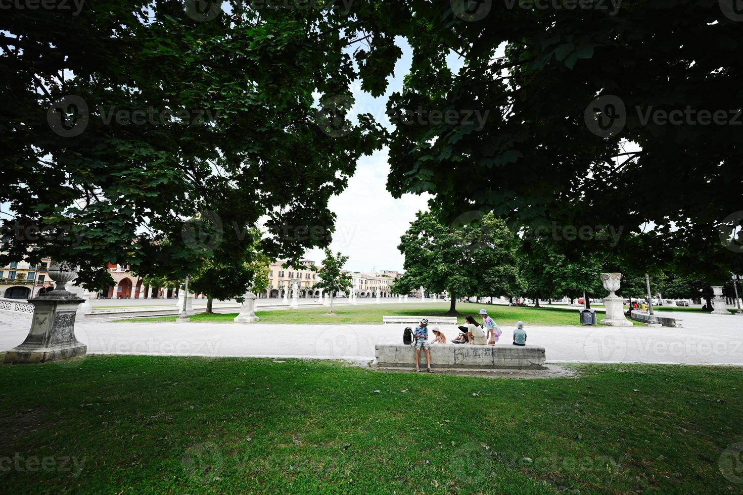 Family rest in park with canal on square Prato della Valle and Basilica Santa Giustina in Padova, Veneto, Italy. photo