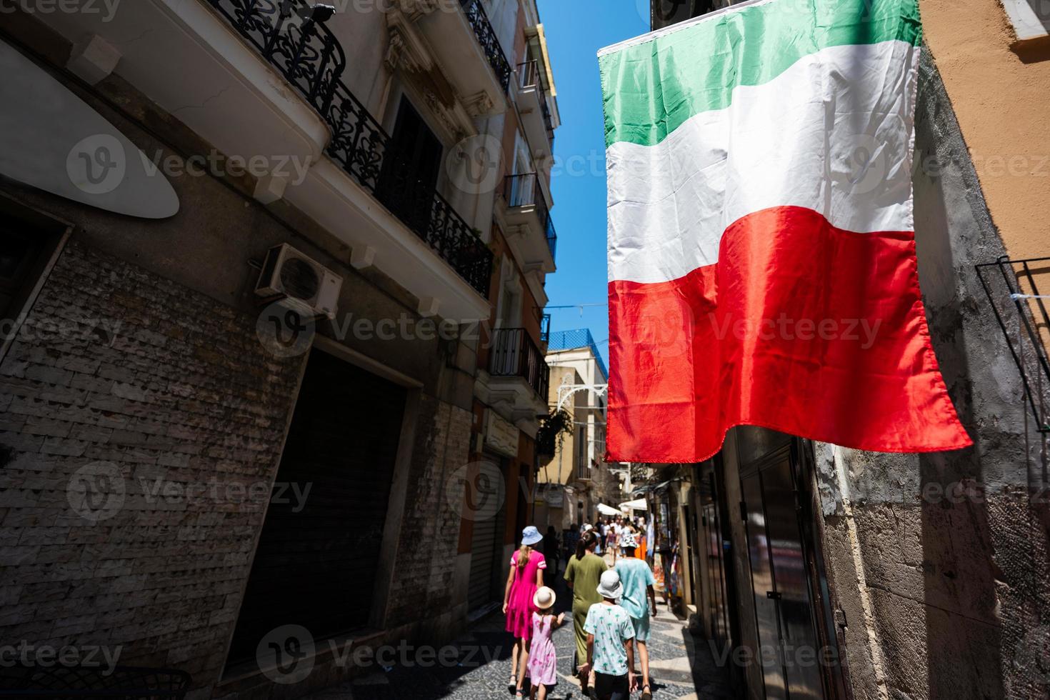 Family of tourists waking in streets Bari, Puglia, South Italy. Italian flag. photo