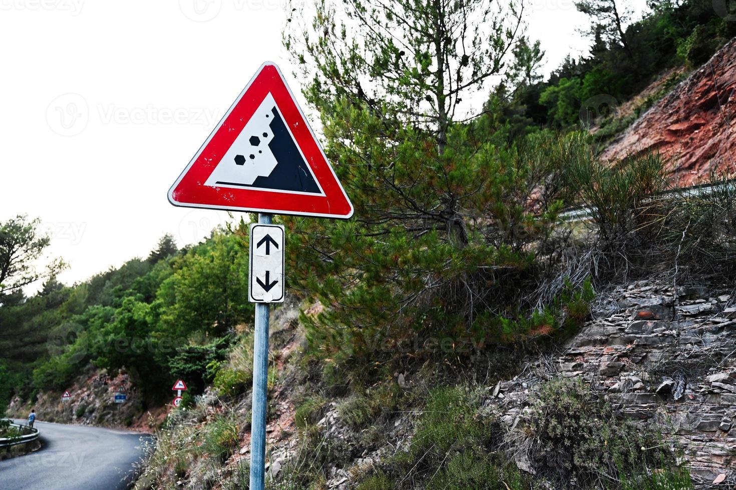 Road sign falling stones, traffic sign caution possible falling rocks. photo