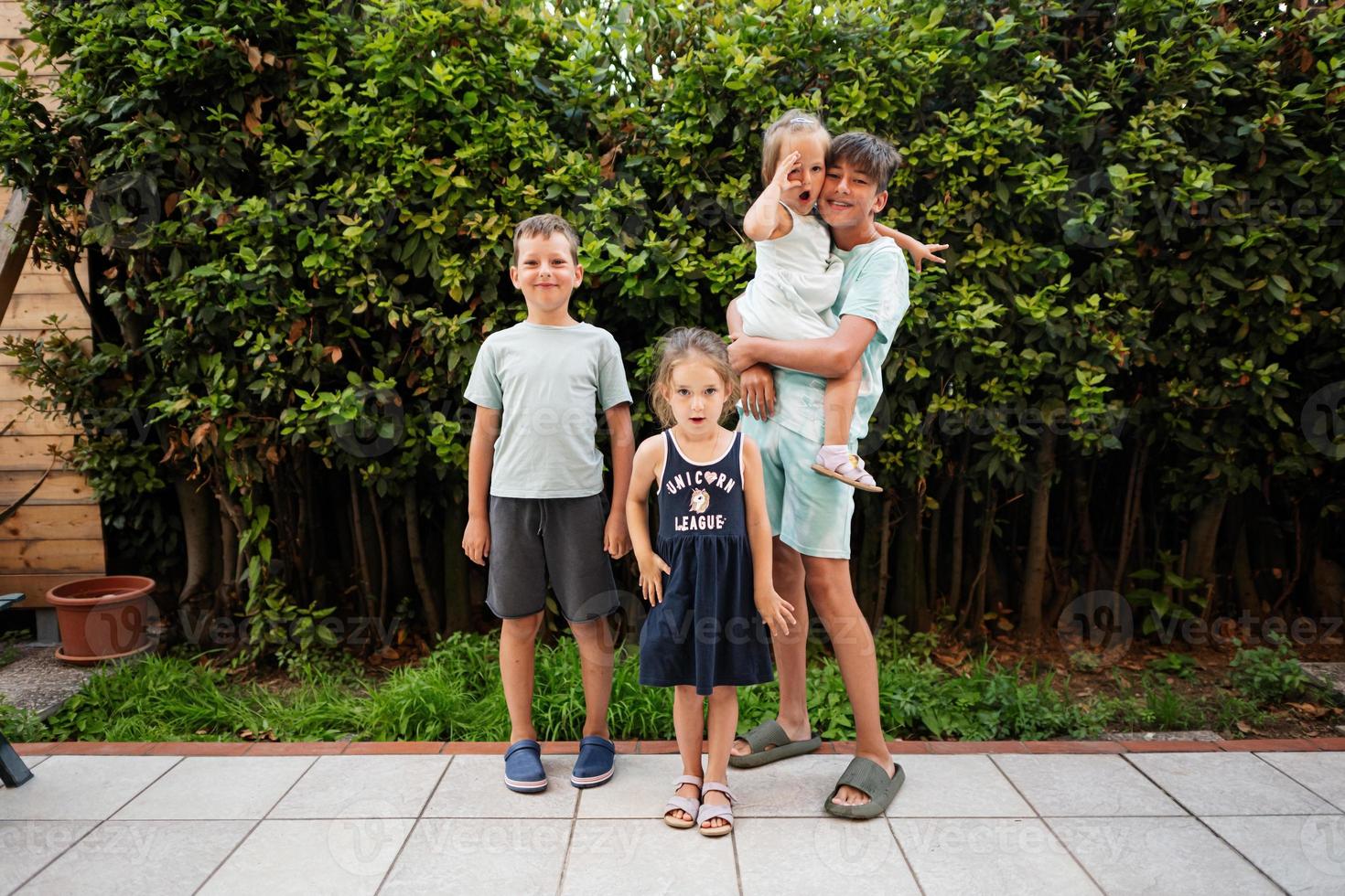 Four happy kids on the terrace of the house. Brothers and sisters. photo