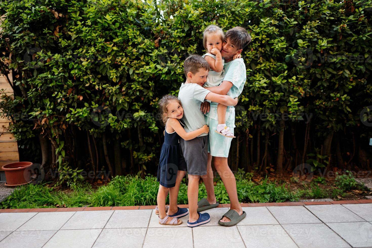 cuatro niños felices en la terraza de la casa. hermanos y hermanas. foto