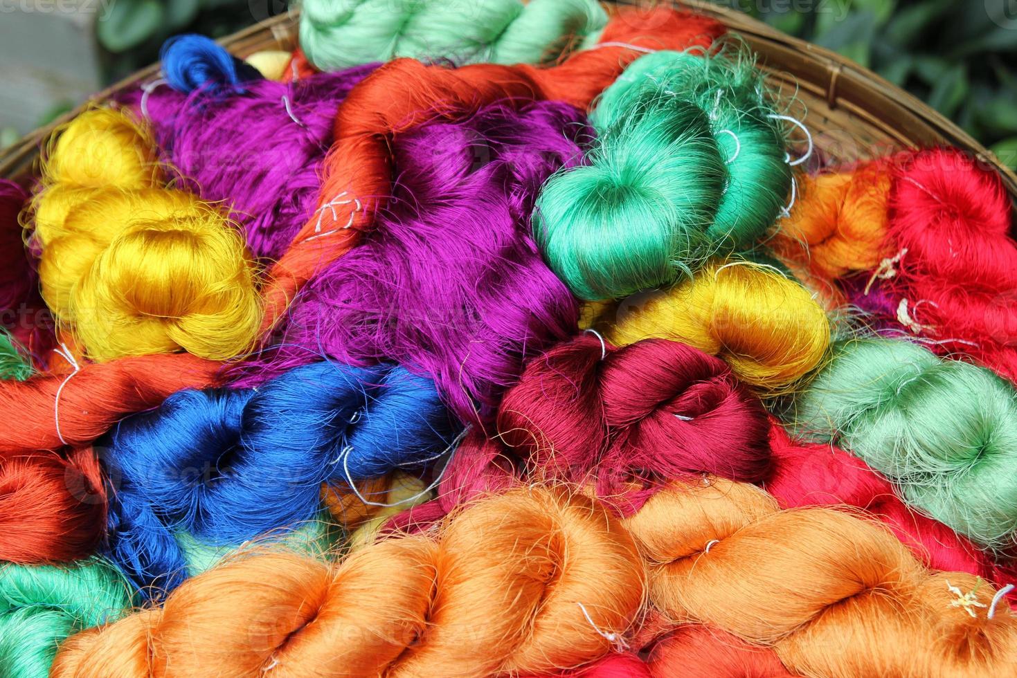 viajar a bangkok, tailandia. hilos coloridos de seda tailandesa en un primer plano de cesta para el fondo. foto