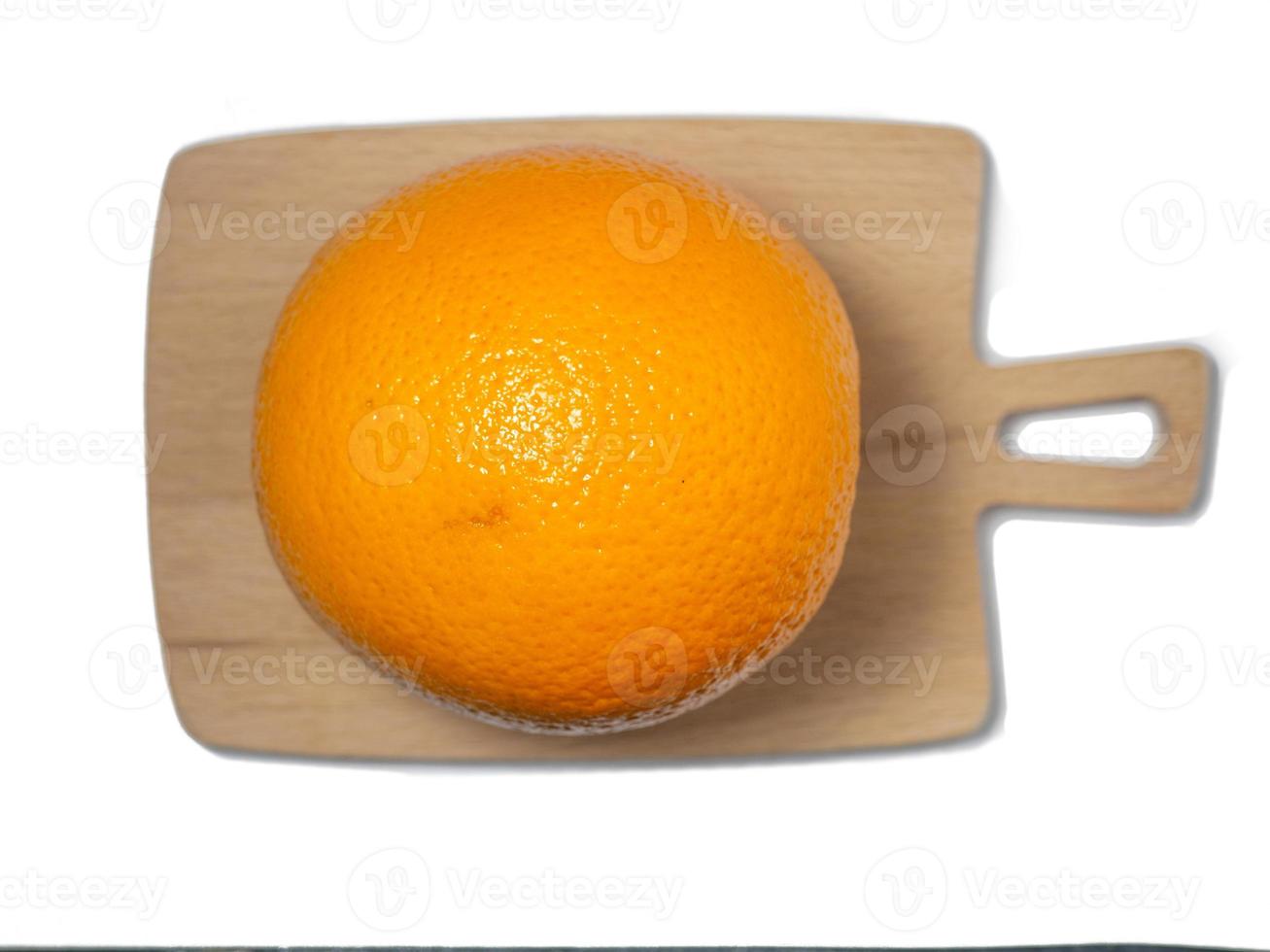 A whole orange on a cutting board. fruit isolate. Juicy orange on the table. photo