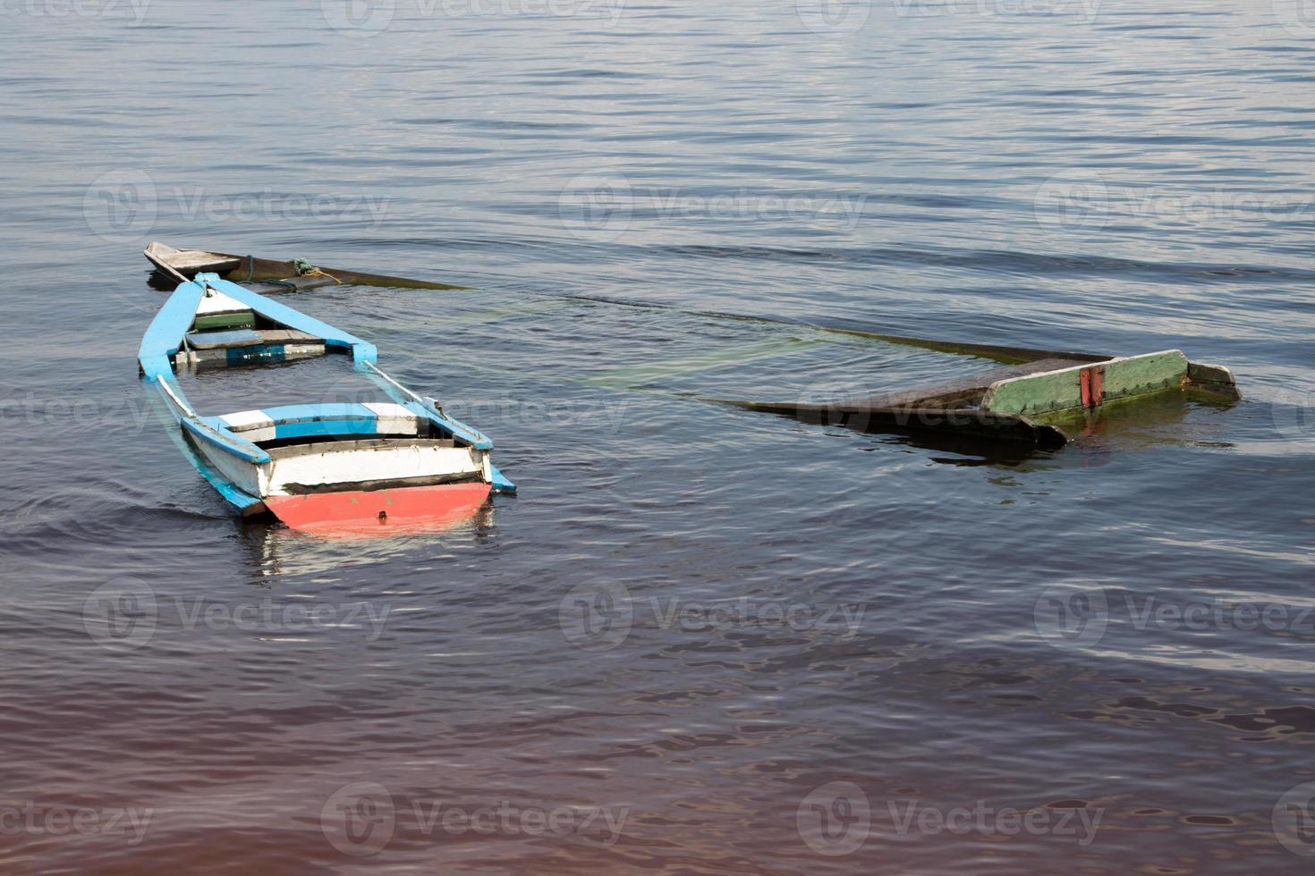 Small old wooden boats filled with water found on the shore of the Rio Negro River in Airao, Brazil photo