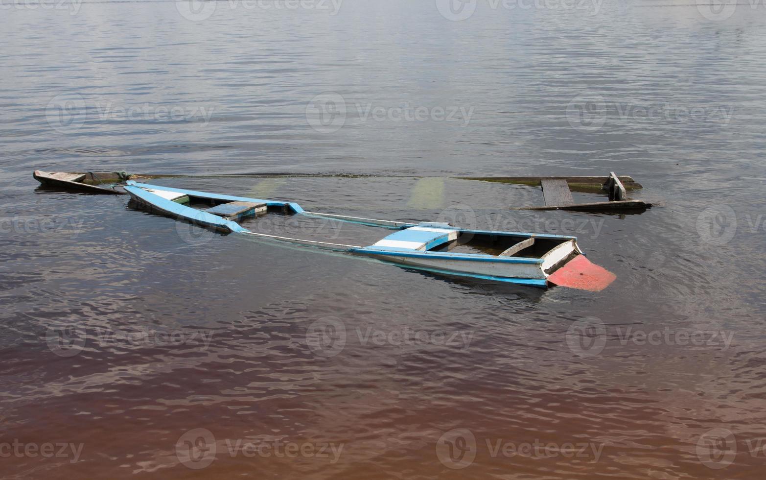 Small old wooden boats filled with water found on the shore of the Rio Negro River in Airao, Brazil photo