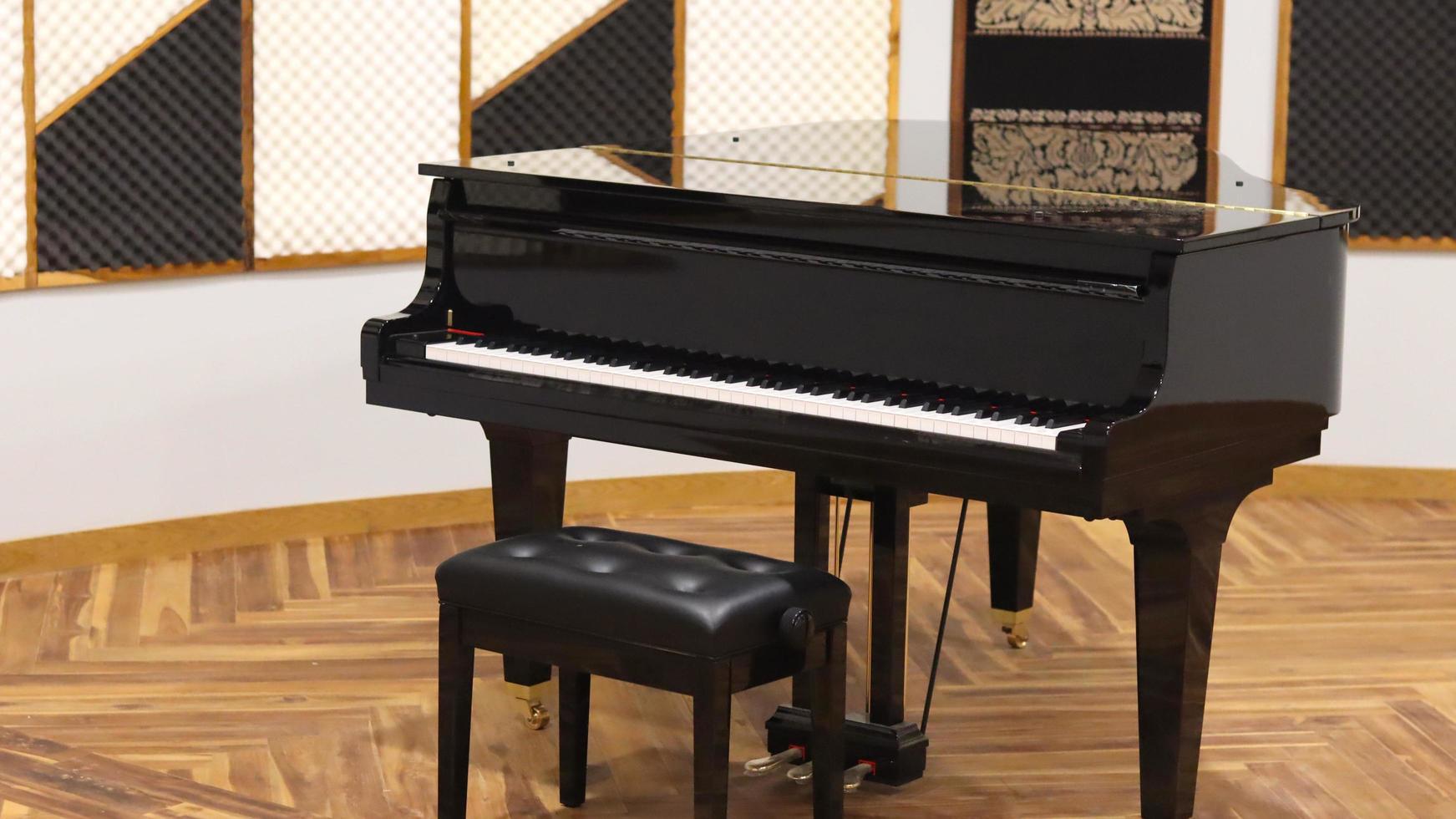 foto de un piano clásico con un fondo de sala de recital batik oranamen