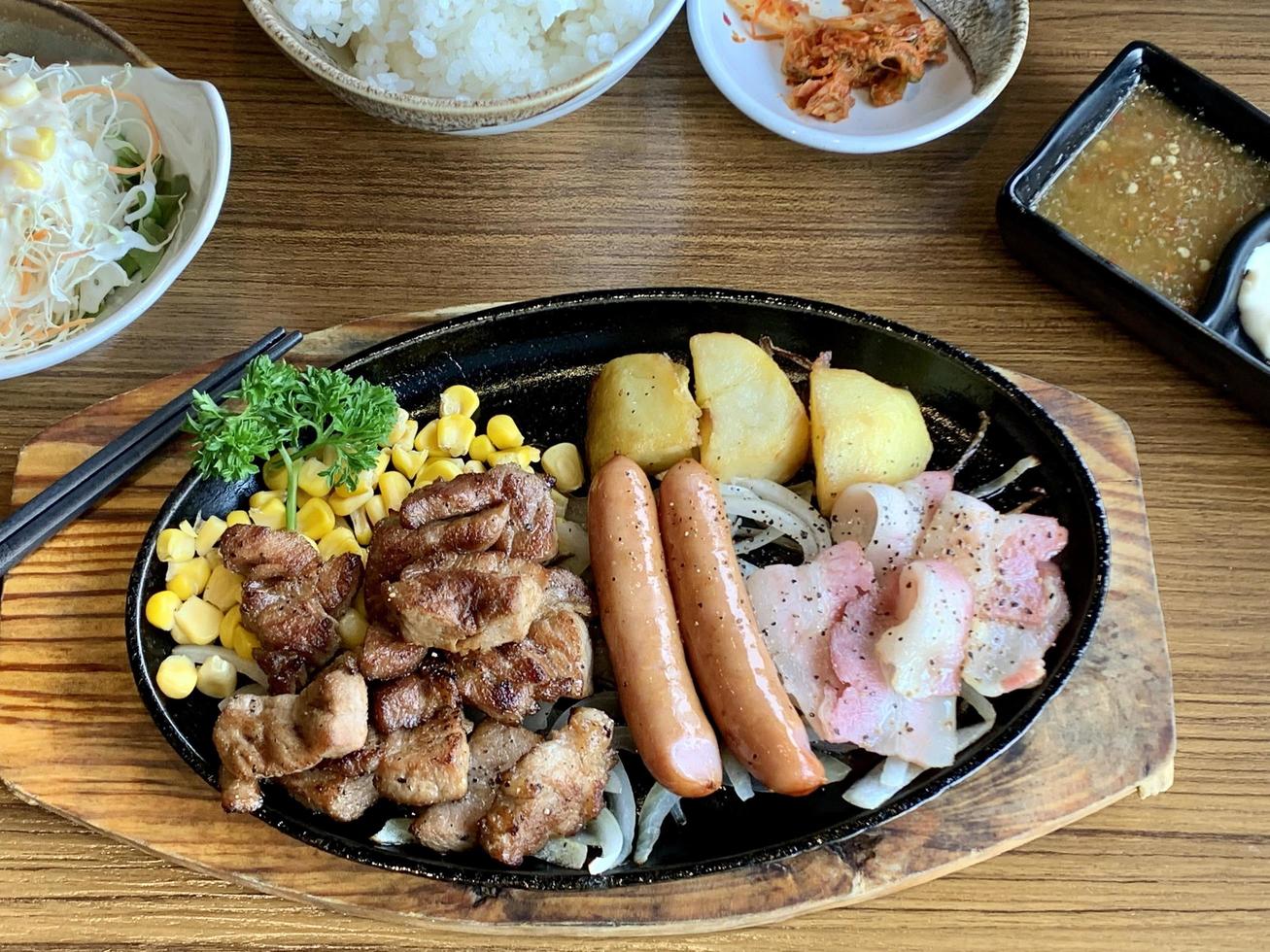 Various menus, sushi, sashimi, nigiri, pan fried pork and miso soup. Sashimi, chutoro sashimi, Japanese food chopsticks and wasabi on the black table, Japanese food style. blurs focus. photo