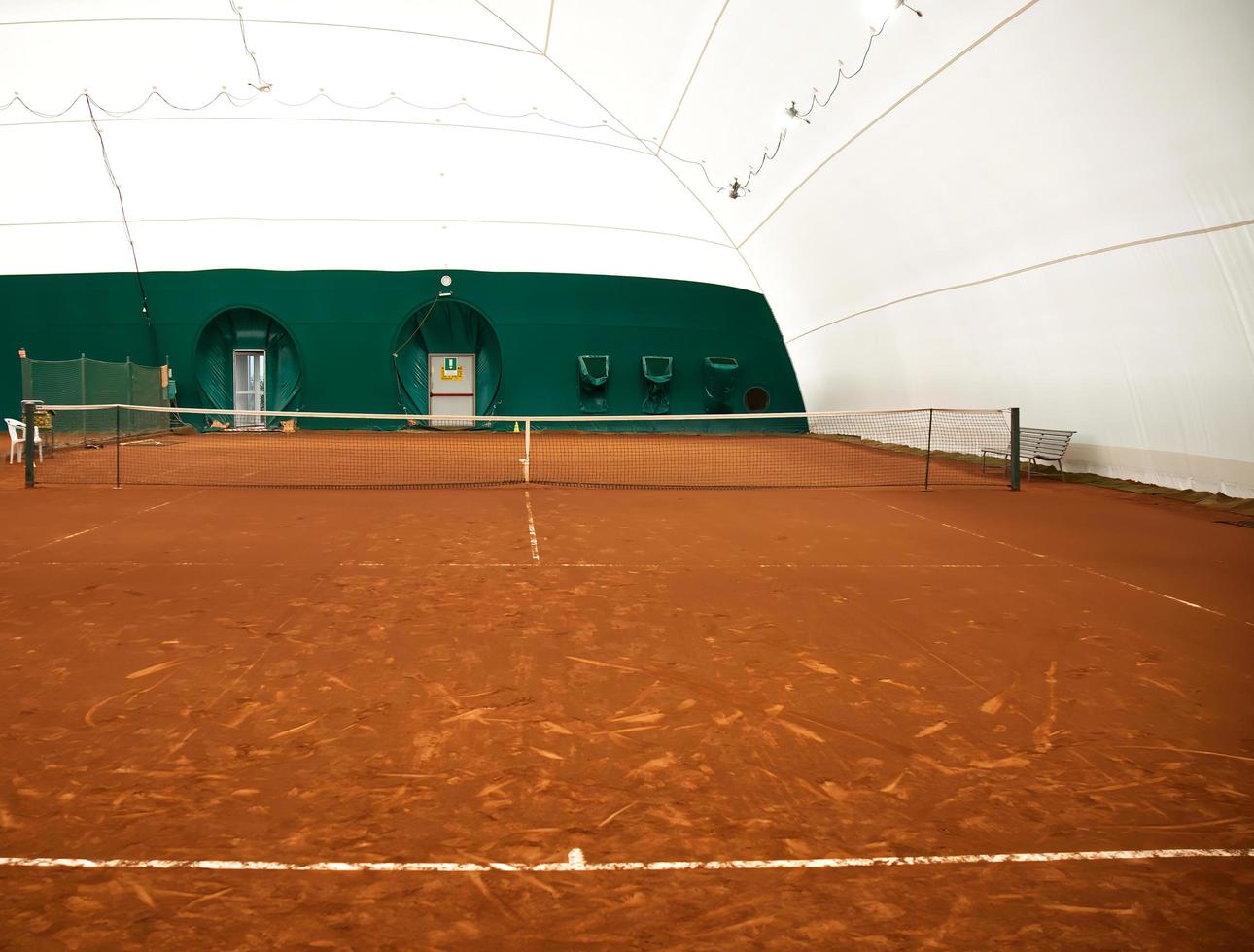 View of empty red clay closed tennis court photo