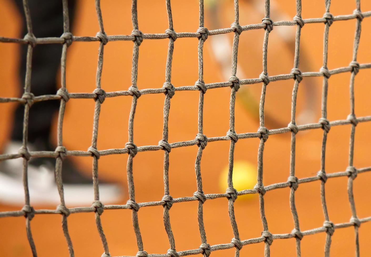 red de tenis en cancha de tenis cerrada de arcilla roja foto