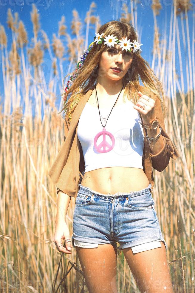 hippie girl with flowers crown if peace symbol photo