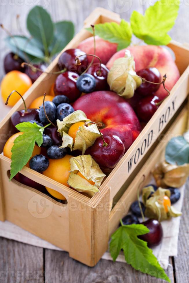 frutas de verano en una caja foto