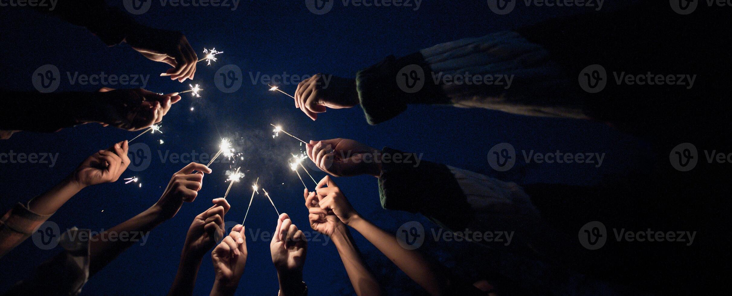 Group of young friends enjoy with burning sparkler in hands together photo