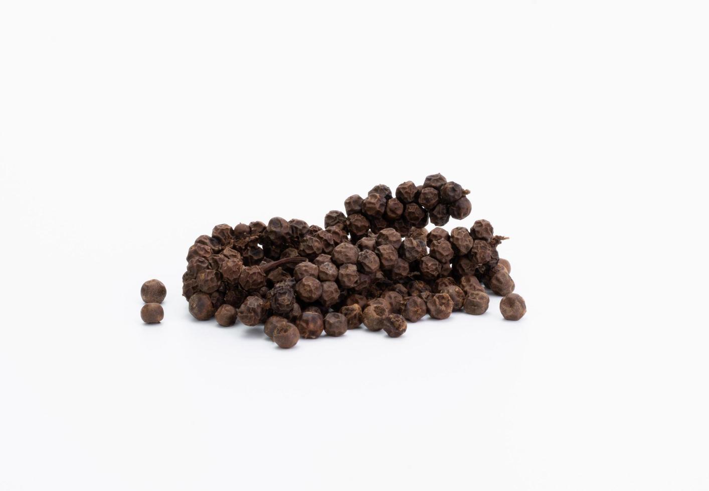 a pile of black pepper seeds food or seasoning Spices, ingredients of regular cooking in the kitchen of Asian, Indian, spicy, hot, natural herbs. pepper seeds isolated on white background photo