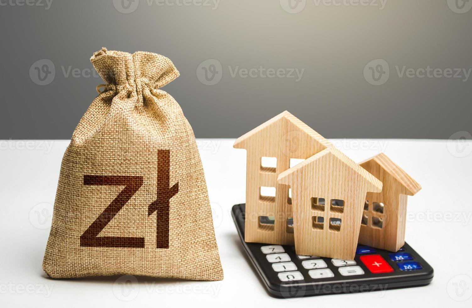 Houses on a calculator and polish zloty money bag. Buying and selling. Real estate valuation. Realty or rental business. Building maintenance. Mortgage loan. Utilities and services expenses. Taxes photo