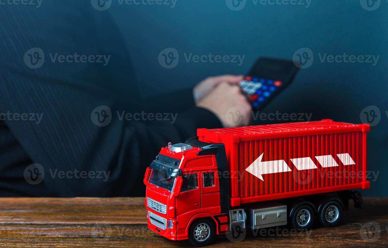 Businessman calculates the cost of shipping. Optimization of delivery costs, routing algorithm. Rising prices, global containers shortage crisis. Transportation inflation, shipping rates. photo