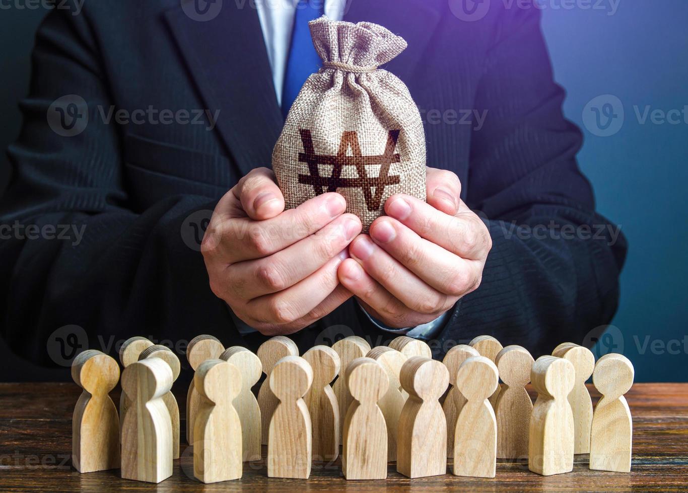 Businessman holds out a south korean won money bag to the crowd. Official. Staff maintenance. Tax collection. Compensation payments. Providing money, paying salaries and grants. Financial support. photo