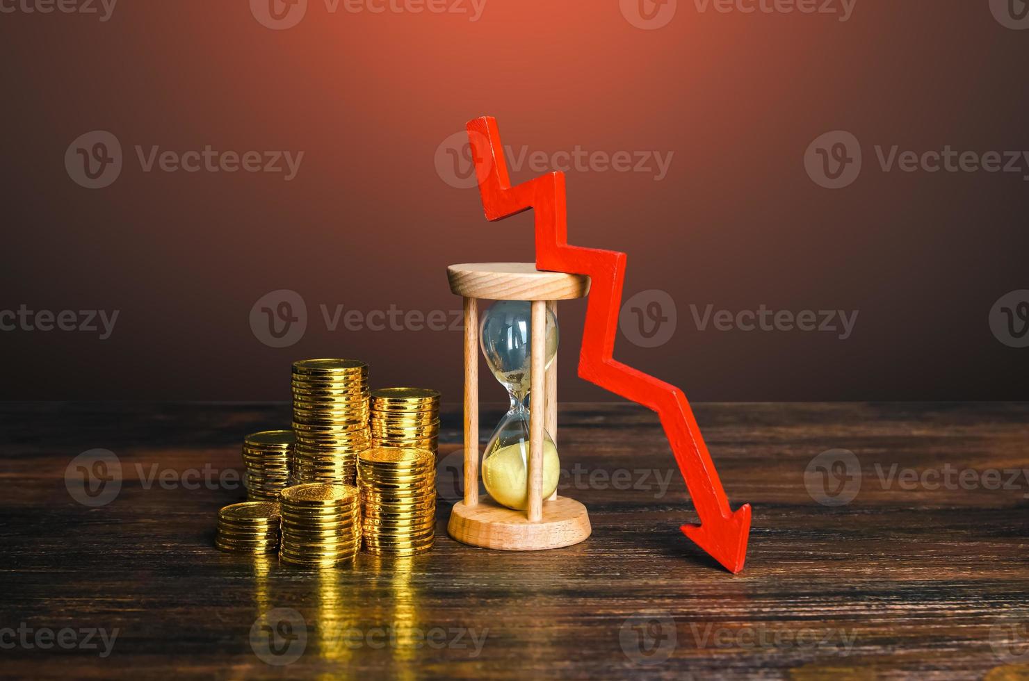 Money, sandglass and down arrow. Decrease in hourly pay wages. Save savings from inflation. Income falling. Dropping mortgage rates. Decreasing return on investment over time. Reducing costs, prices photo