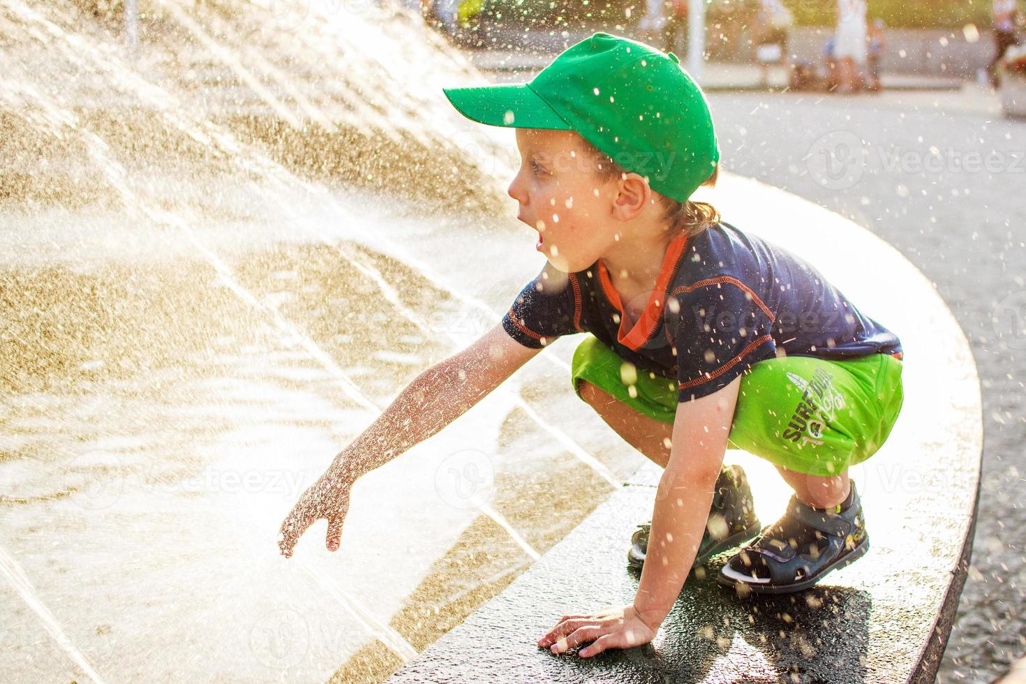 Boy playing outdoors with a fountain photo