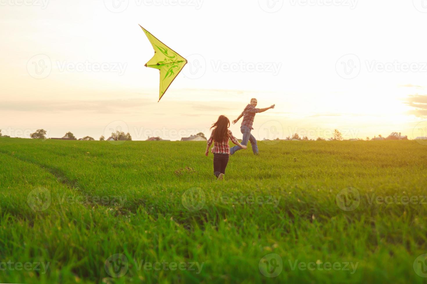 familia lanza una cometa en el campo foto