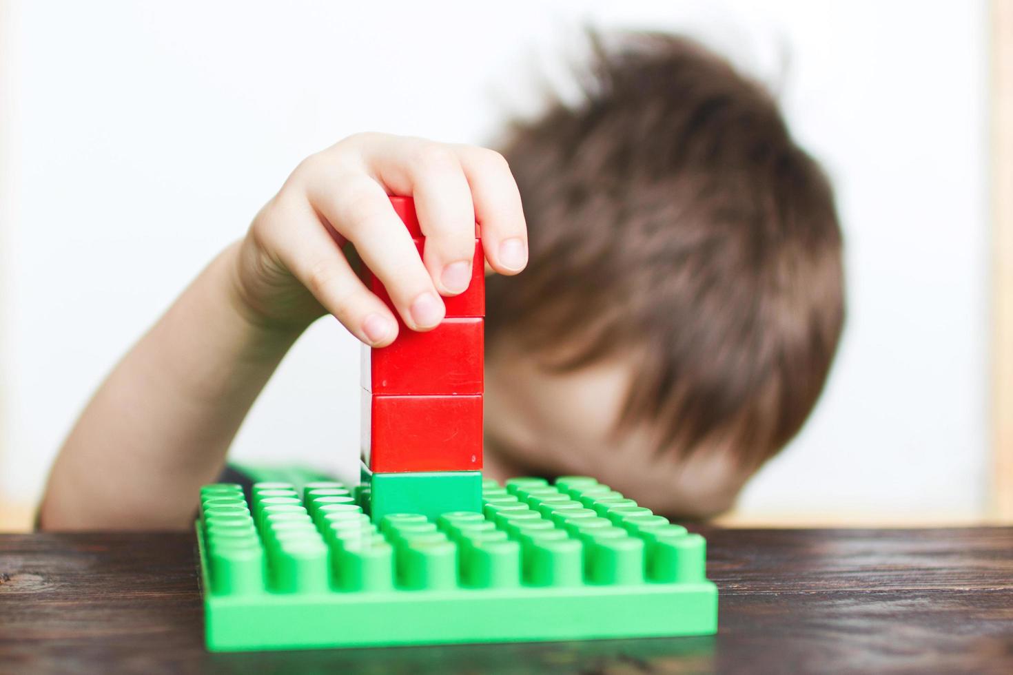 niño jugando con constructor de plástico foto