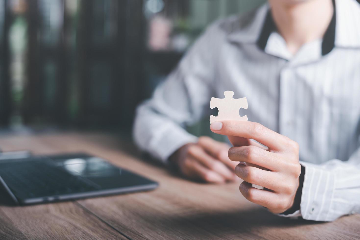 Businessman holding a puzzle piece to find a business solution,Connecting success and problem solution, from creativity,and strategic planning to develop the organization into the future photo