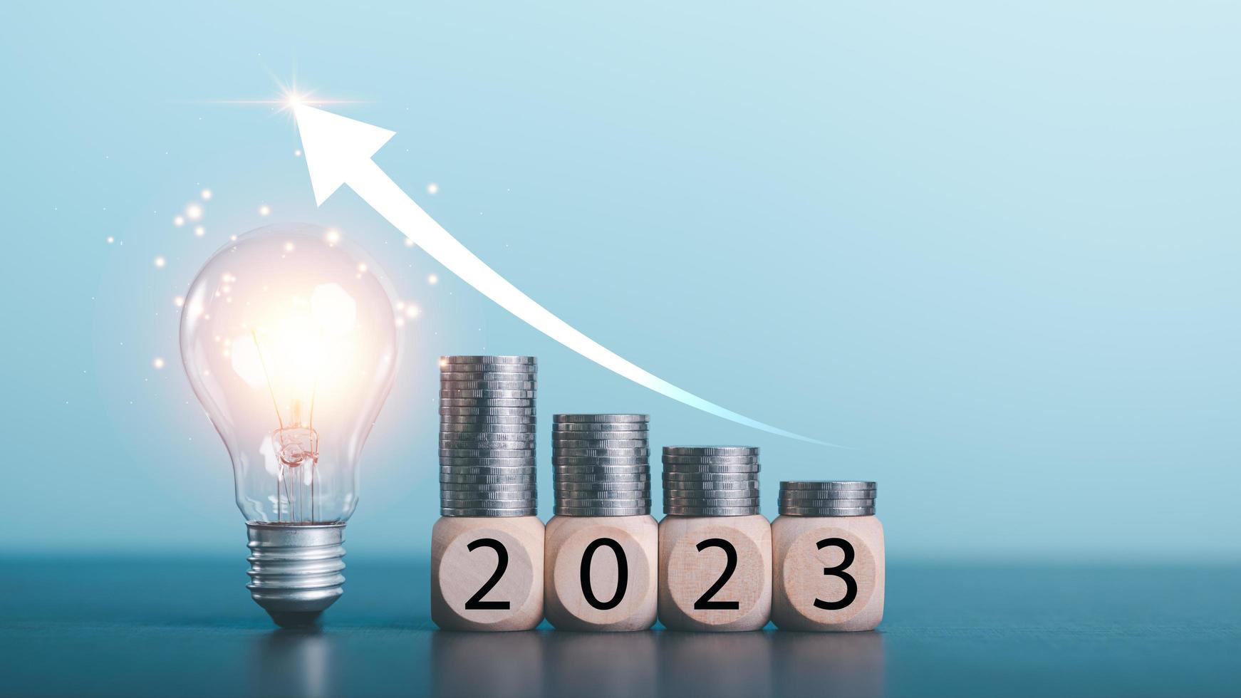 New Year start concepts,Light bulbs, coins on wooden blocks all on the table,saving money for future goals,Business targeting and focus concept,the growth and purpose of the organization, photo