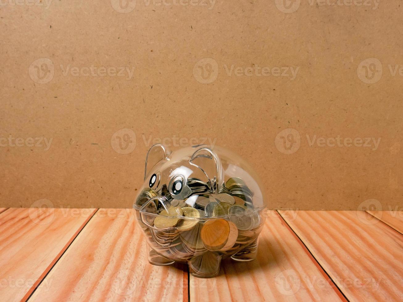 The piggy bank on wood table for earn or saving concept photo