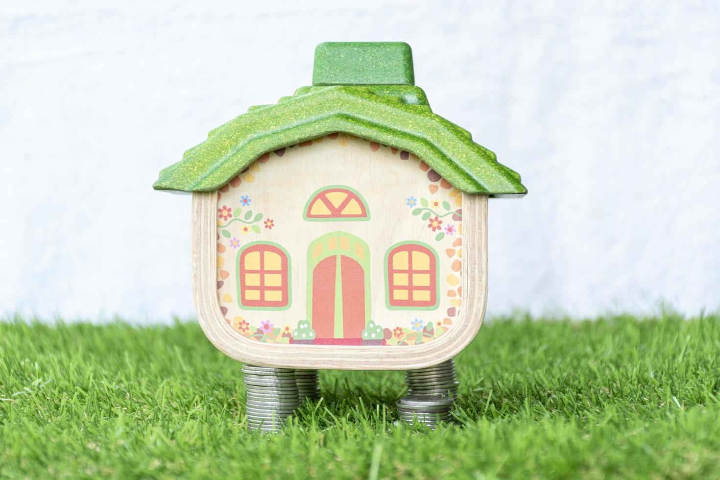 Mock up house on coins stack and grass floor photo