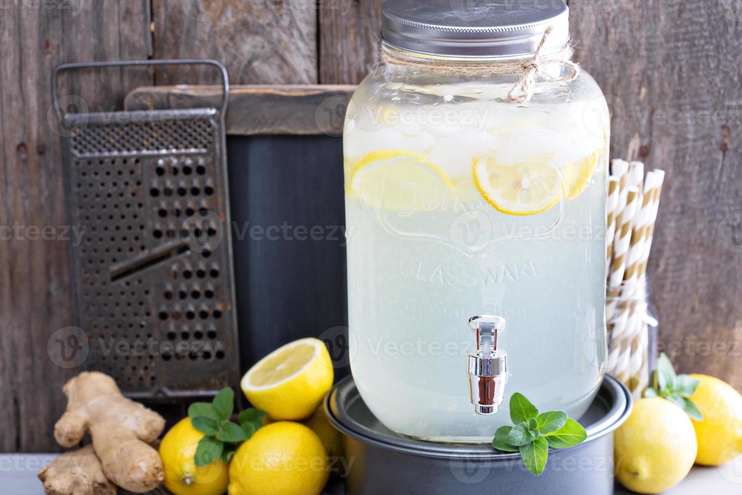 Ginger homemade lemonade in a beverage dispenser photo