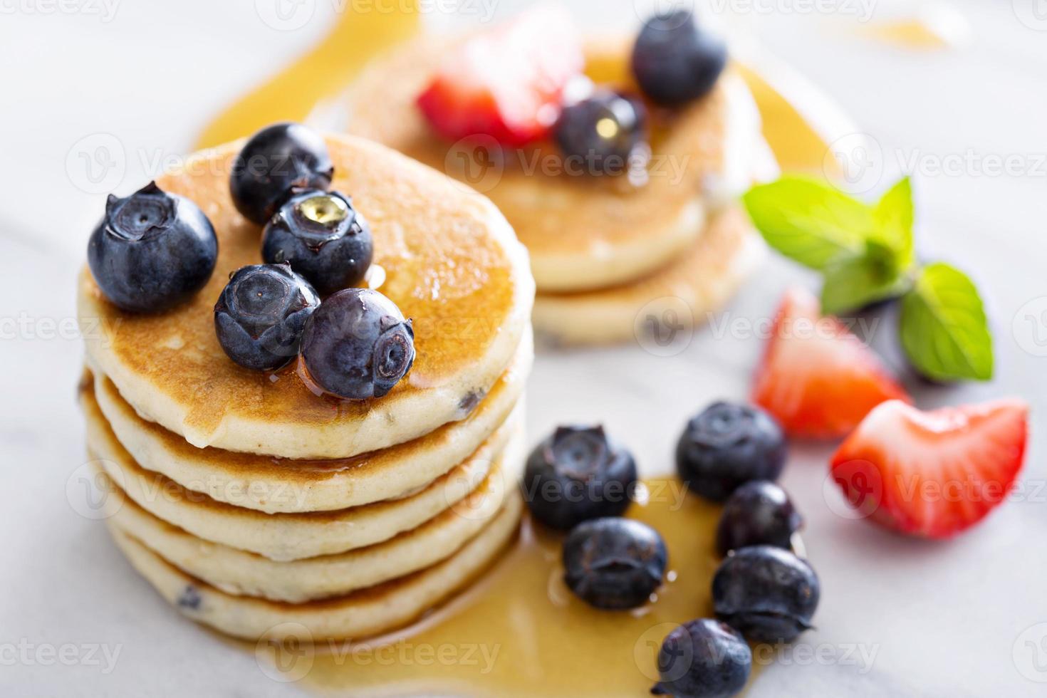 Stack of small pancakes with fresh berries photo