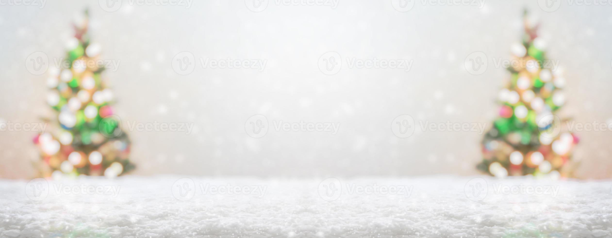 Empty white snow with blur Christmas tree with bokeh light background photo